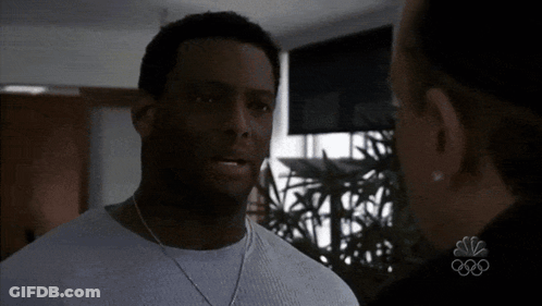 Man In White Shirt Talking To Woman With NBC Logo GIF