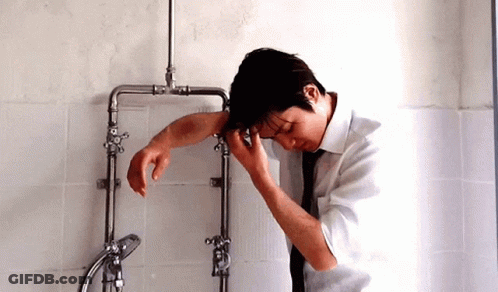 Man In White Shirt Tie Leaning On Pipes GIF