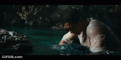 Man In White Shirt Touching Rock In Water GIF