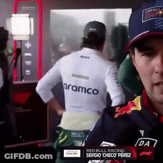 Man In White Shirt With Aramco On Back In Front Of Mirror GIF