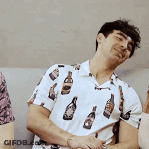 Man In White Shirt With Bottles Sitting On Couch GIF