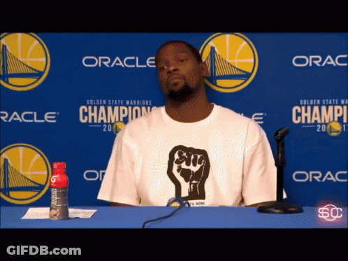 Man In White Shirt With Fist Sitting GIF