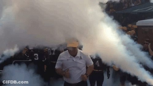 Man In White Shirt With Letter A Walking Through Smoke GIF