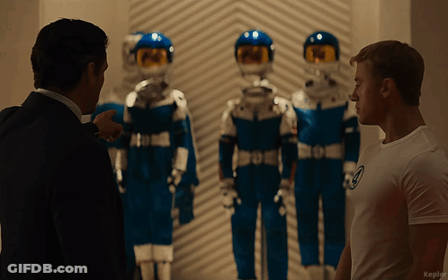 Man In White Shirt With Number 4 Next To Man In Suit GIF