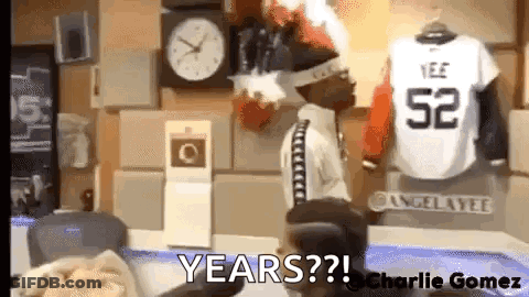 Man In White Shirt With Number 52 In Front Of Clock GIF