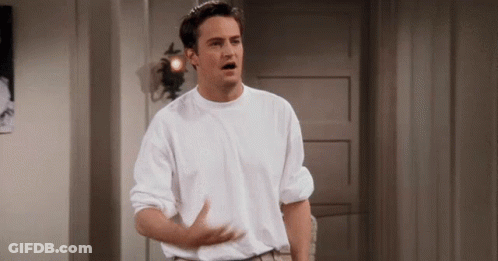 Man In White Shirt With Outstretched Arms In Hallway GIF