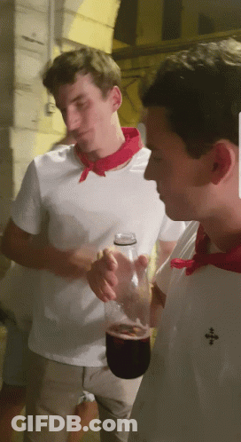 Man In White Shirt With Red Scarf Holding Wine GIF