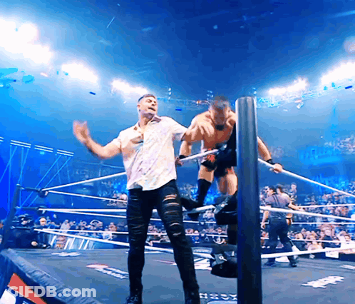 Man In White Shirt Wrestling In Ring Next To Man In Black Jeans GIF