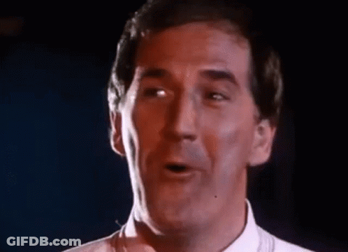 Man In White Singing Funny Face Into Microphone GIF