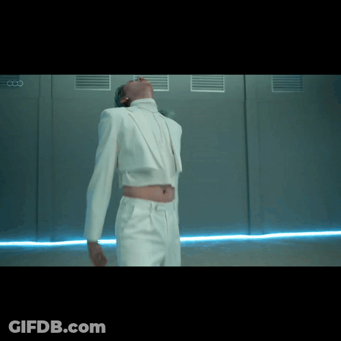 Man In White Suit Beside Wall With Letter CC GIF