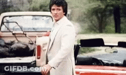Man In White Suit By Truck And Red Car GIF