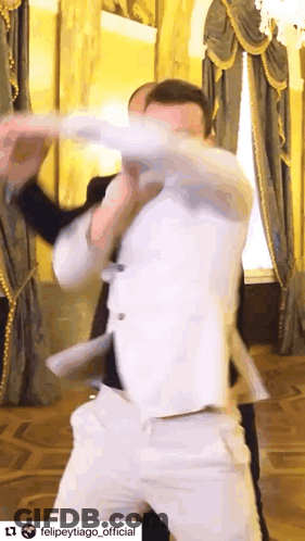Man In White Suit Dancing In Front Of Window GIF