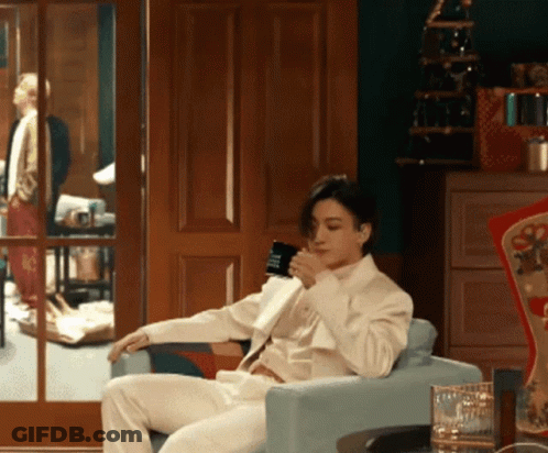 Man In White Suit Drinking From Cup GIF