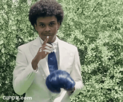 Man In White Suit Holding Blue Glove GIF