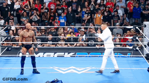 Man In White Suit In Wrestling Ring With Two Men GIF
