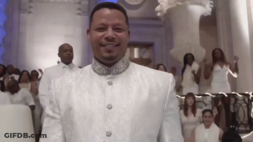 Man In White Suit Smiling In Front Of Group GIF