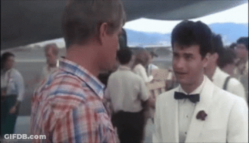 Man In White Suit Talking To Man In Plaid Shirt GIF