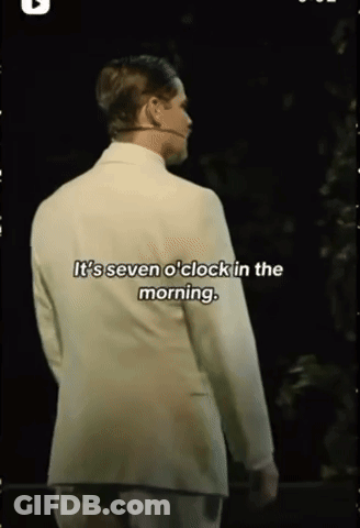Man In White Suit With Microphone Says It's Seven O'Clock In The Morning GIF
