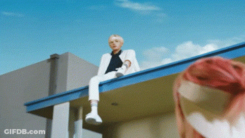 Man In White Suit With Pink-Haired Woman On Roof GIF