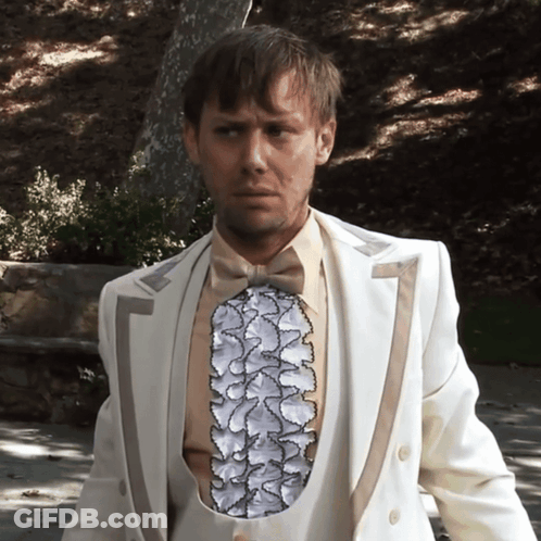 Man In White Suit With Ruffled Vest GIF