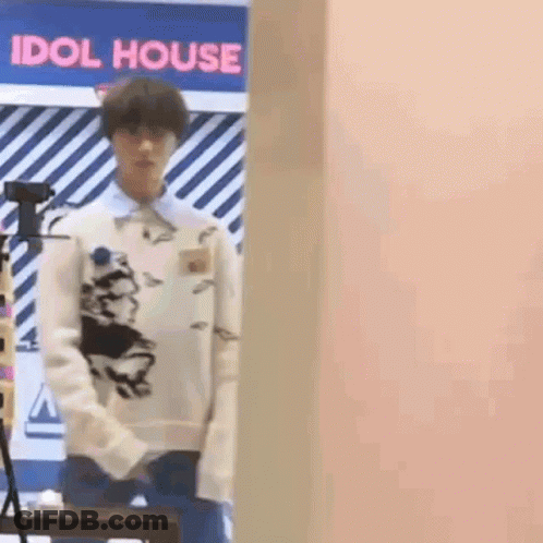 Man In White Sweater In Front Of Pink Wall GIF