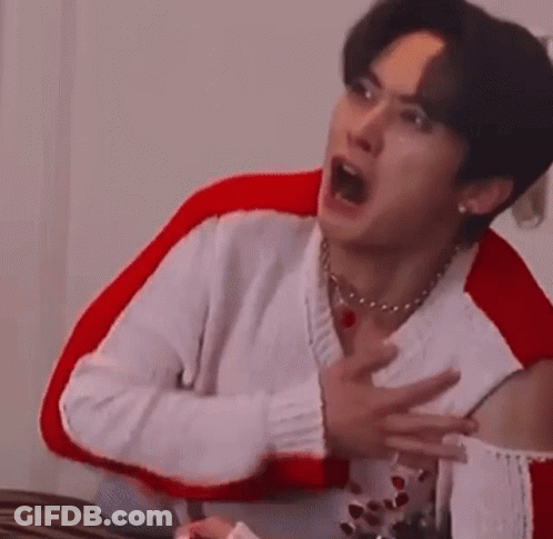 Man In White Sweater Making Face In Red Chair GIF