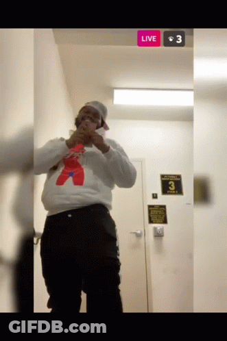 Man In White Sweatshirt And Red Bear At Door With Live Button GIF