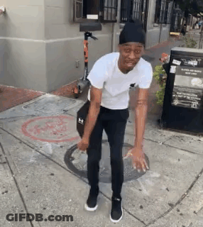 Man In White T-Shirt And Black Pants Standing Next To Scooter GIF