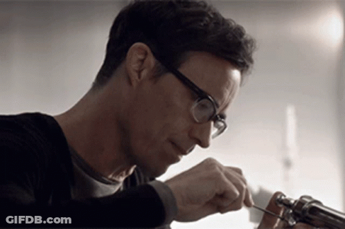 Man In White T-Shirt And Necklace Sitting By Window GIF