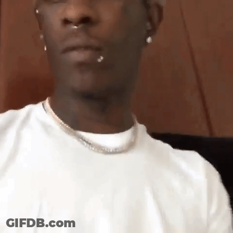 Man In White T-Shirt And Necklace Sitting Down GIF