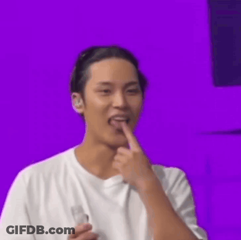 Man In White T-Shirt Holding Bottle And Licking Finger GIF