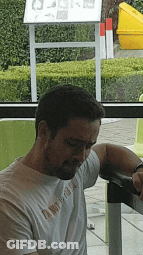 Man In White T-Shirt Saying I'm Not A Fan At Table GIF