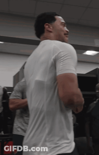 Man In White T-Shirt Standing In Locker Room GIF
