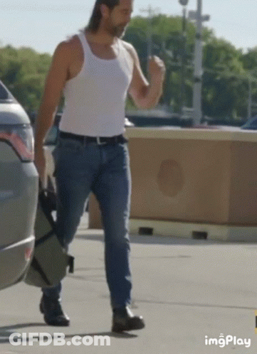 Man In White Tank Top And Blue Jeans Walking GIF