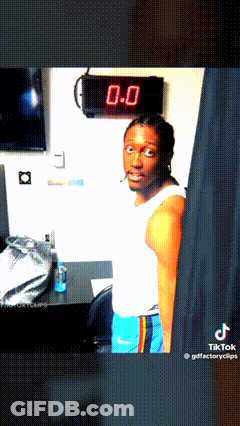 Man In White Tank Top And Blue Shorts In Front Of Clock Saying 0.0 GIF