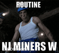 Man In White Tank Top And Blue Shorts In Front Of Routine NJ Miners Sign GIF