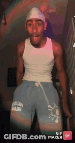 Man In White Tank Top And Blue Shorts Standing In Room GIF