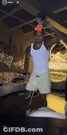 Man In White Tank Top And Shorts Holding Bottle GIF
