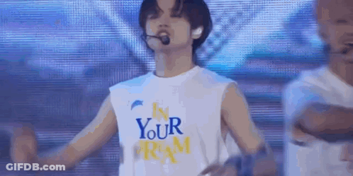 Man In White Tank Top Arms Outstretched On Stage GIF
