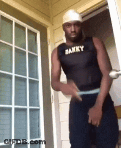 Man In White Tank Top Covering Face With Black Gloves GIF