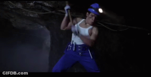 Man In White Tank Top Digging In Cave GIF