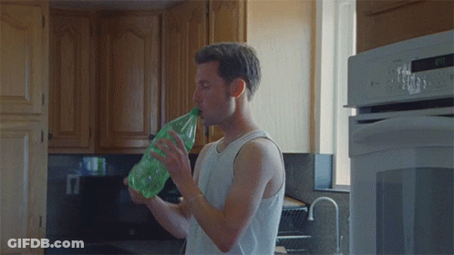 Man In White Tank Top Drinking From Green Bottle GIF