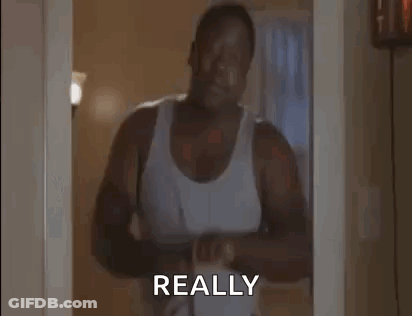 Man In White Tank Top Holding Belt At Doorway GIF