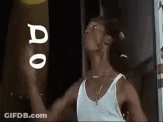 Man In White Tank Top Holding Frisbee In Front Of Do Sign GIF