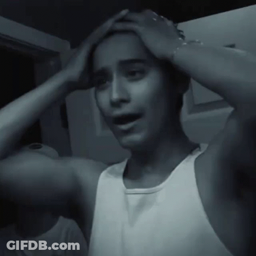 Man In White Tank Top Holding Head Black And White GIF