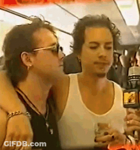 Man In White Tank Top Holding Microphone And Talking GIF