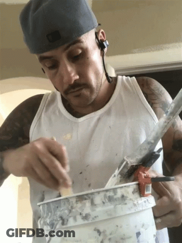 Man In White Tank Top Holding Paint Bucket GIF