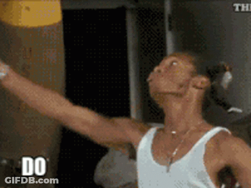 Man In White Tank Top Holding Yellow Object GIF