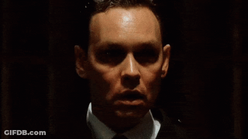 Man In White Tank Top In Dark Brick Room GIF