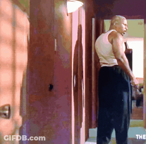 Man In White Tank Top In Hallway GIF